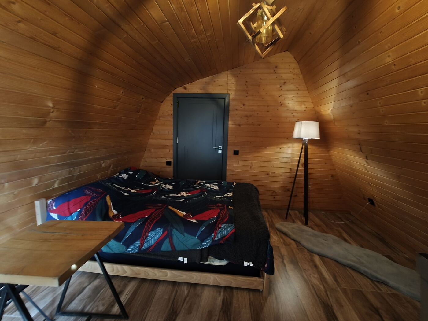 Inside a glamping bungalow at Teddy Camp, bed and warm lighting