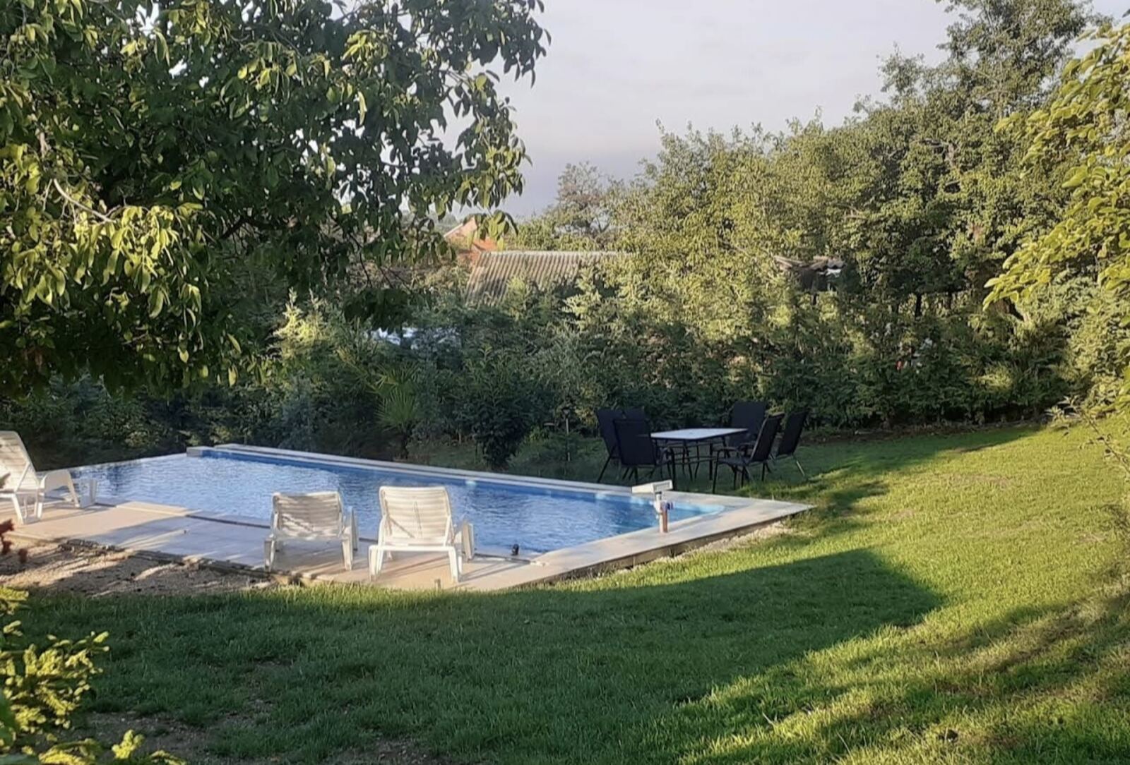 Swimming pool at golden hour with dining table at Teddy Camp guesthouse Kosovo